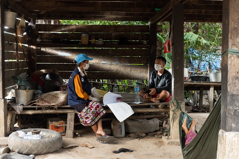 A health worker sits with a local farmer